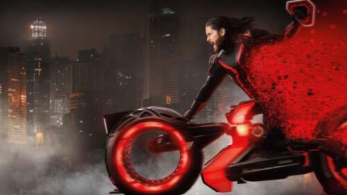 Jared Leto riding a neon-lit Light Cycle in the digital landscape of Tron: Ares high definition wallpaper