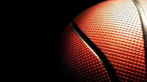 Close-up of a textured basketball on a black background wallpaper for laptop download