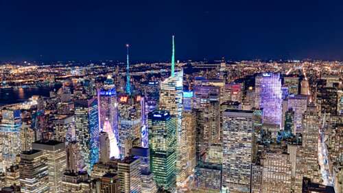 A panoramic night view of the New York City skyline featuring brightly lit skyscrapers... pictures for wallpaper