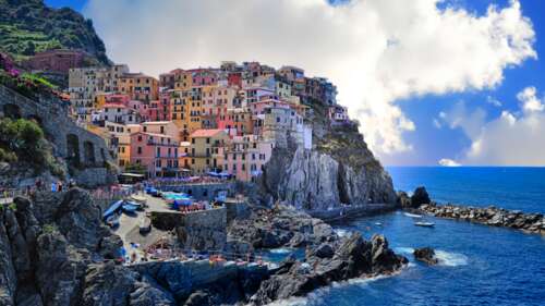 A panoramic view of the colorful seaside village of Manarola in Cinque Terre, Italy,... wallpaper