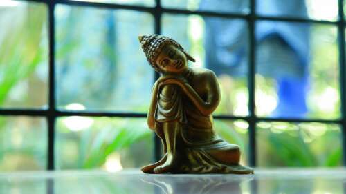 A peaceful and highly detailed sculpture of Buddha in a meditative state. wallpaper