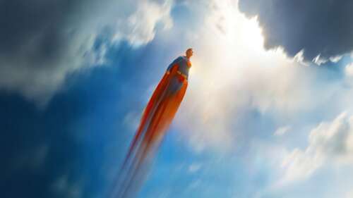 Superman flying high through the clouds in the DC Superheroes universe. free background images