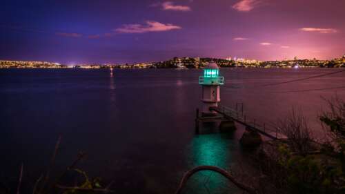 A lighthouse overlooking the sparkling city lights of Sydney Harbour, Australia,... wallpaper download