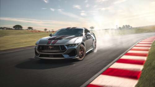 A high-performance racing vehicle speeding through a professional race track circuit,... wallpaper