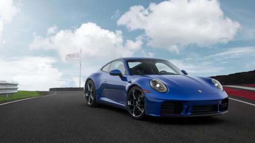 A sleek and modern 2026 Porsche 911 Carrera speeding along a professional race track. hd background