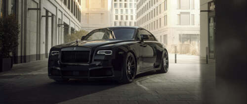 A close-up view of a luxurious black Rolls-Royce Wraith automobile parked in a sophisticated... UWUHD high definition wallpaper