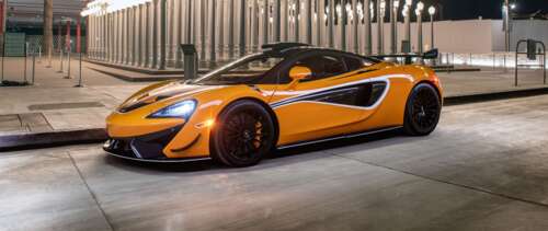 A sleek and vibrant orange McLaren 620R supercar highlighting its aerodynamic curves... UWUHD free background