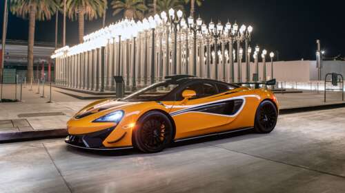 A sleek and vibrant orange McLaren 620R supercar highlighting its aerodynamic curves... 8K desktop wallpaper