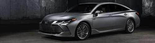 A close-up shot of a silver Toyota Avalon sedan with a metallic finish. Dual UHD