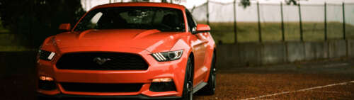 A classic Ford Mustang muscle car featuring its signature aggressive automotive design. Dual UHD hd background