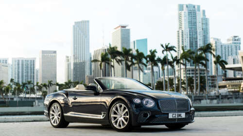 A premium black Bentley Continental GT Cabriolet featuring a glossy exterior and... 8K wallpaper