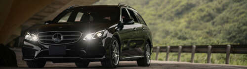 A glossy black Mercedes-Benz E-Class luxury sedan. Dual UHD free background images