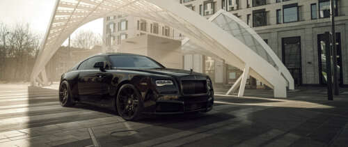 A luxurious black Rolls-Royce Wraith with a glossy finish and elegant automotive... UWUHD desktop wallpaper