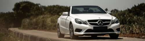 A luxurious white Mercedes-Benz E-Class convertible car. Dual UHD wallpaper for laptop download