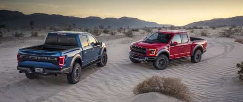 A Ford F-150 Raptor truck driving through a sandy desert landscape under bright sunlight. UWUHD free desktop wallpaper