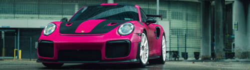 A vibrant pink Porsche 911 GT2 RS luxury sports car Dual UHD wallpaper images