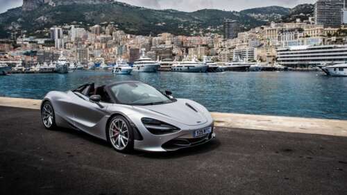 A polished silver McLaren 720S supercar parked on a scenic street in Monaco. wallpaper