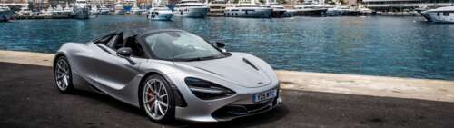 A polished silver McLaren 720S supercar parked on a scenic street in Monaco. Dual UHD background images hd
