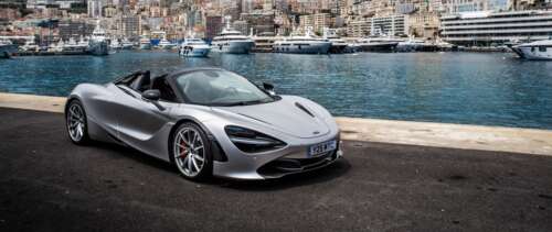A polished silver McLaren 720S supercar parked on a scenic street in Monaco. UWUHD desktop wallpaper