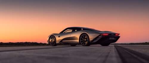 A silver McLaren Speedtail supercar parked under a beautiful sunset sky. wallpaper