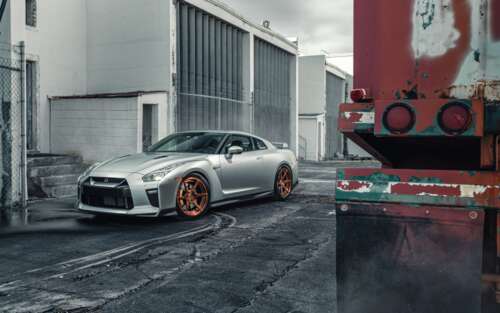 A sleek silver Nissan GT-R supercar featuring a metallic finish and aerodynamic body. wallpaper