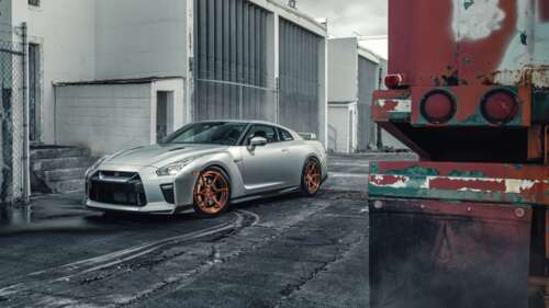 A sleek silver Nissan GT-R supercar featuring a metallic finish and aerodynamic body. 8K free wallpaper for computer