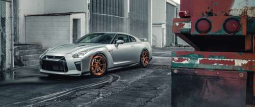 A sleek silver Nissan GT-R supercar featuring a metallic finish and aerodynamic body. UWUHD free background images