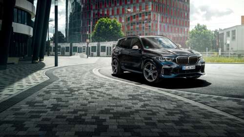 A sleek and shiny black BMW X5 luxury SUV parked in a professional setting. wallpaper download