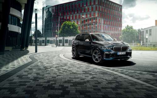A sleek and shiny black BMW X5 luxury SUV parked in a professional setting. 7680x4800 wallpaper images