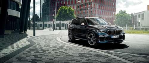 A sleek and shiny black BMW X5 luxury SUV parked in a professional setting. UWUHD ps4 wallpaper