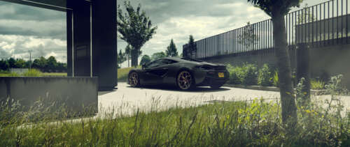 A glossy black McLaren 570S supercar featuring aerodynamic lines and a premium finish. UWUHD
