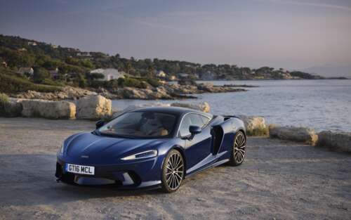 A high-resolution close-up of a sleek McLaren GT supercar highlighting its aerodynamic... 7680x4800 free background