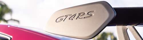 A detailed close-up of a polished Porsche sports car featuring sleek lines and reflective... wallpaper