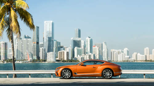 A premium orange Bentley Continental GT showcasing its luxurious design and vibrant... free background