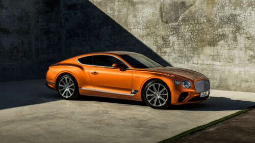 A glossy orange Bentley Continental GT luxury car parked in a scenic setting 4K (Ultra HD) free desktop wallpaper