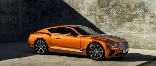 A glossy orange Bentley Continental GT luxury car parked in a scenic setting UWUHD wallpaper for pc download