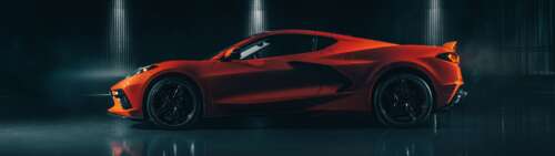 A sleek and vibrant orange Chevrolet Corvette C8 supercar highlighting its mid-engine... Dual UHD pictures for wallpaper