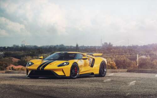 A sleek and powerful yellow Ford GT supercar showcasing its aerodynamic design and... 7680x4800 wallpaper download