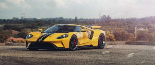 A sleek and powerful yellow Ford GT supercar showcasing its aerodynamic design and... UWUHD pictures for wallpaper