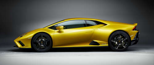 A sleek and bright yellow Lamborghini Huracán Evo supercar showcasing its aerodynamic... UWUHD free background