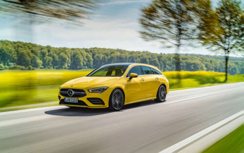A bright yellow Mercedes-Benz CLA-Class luxury sedan showing its aerodynamic design. wallpaper