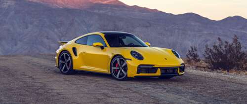 A bright yellow Porsche 911 Turbo sports car featuring a sleek and aerodynamic design. wallpaper