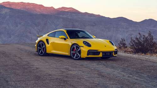 A bright yellow Porsche 911 Turbo sports car featuring a sleek and aerodynamic design. 8K wallpaper for laptop download