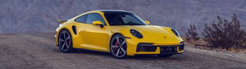 A bright yellow Porsche 911 Turbo sports car featuring a sleek and aerodynamic design. Dual UHD wallpaper download