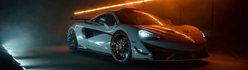 A detailed shot of a white McLaren 620R supercar featuring its modern aerodynamic... Dual UHD computer backgrounds