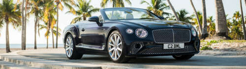 A luxury black Bentley Continental GT convertible showcasing its sleek and polished... Dual UHD free background images
