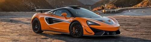 A vibrant orange McLaren 620R supercar featuring sleek aerodynamic lines and a high-performance... Dual UHD hd background