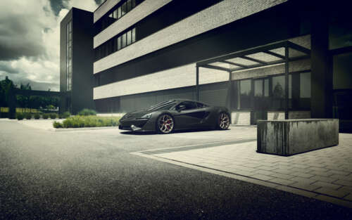 A glossy black McLaren 570S supercar showcasing its sleek aerodynamic design. 7680x4800 wallpaper for pc download