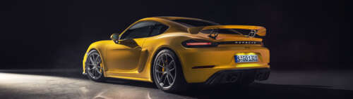 A vibrant yellow Porsche 718 Cayman sports car. Dual UHD wallpaper photo gallery download