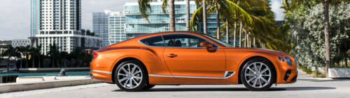 A sleek orange Bentley Continental GT luxury car. free wallpaper